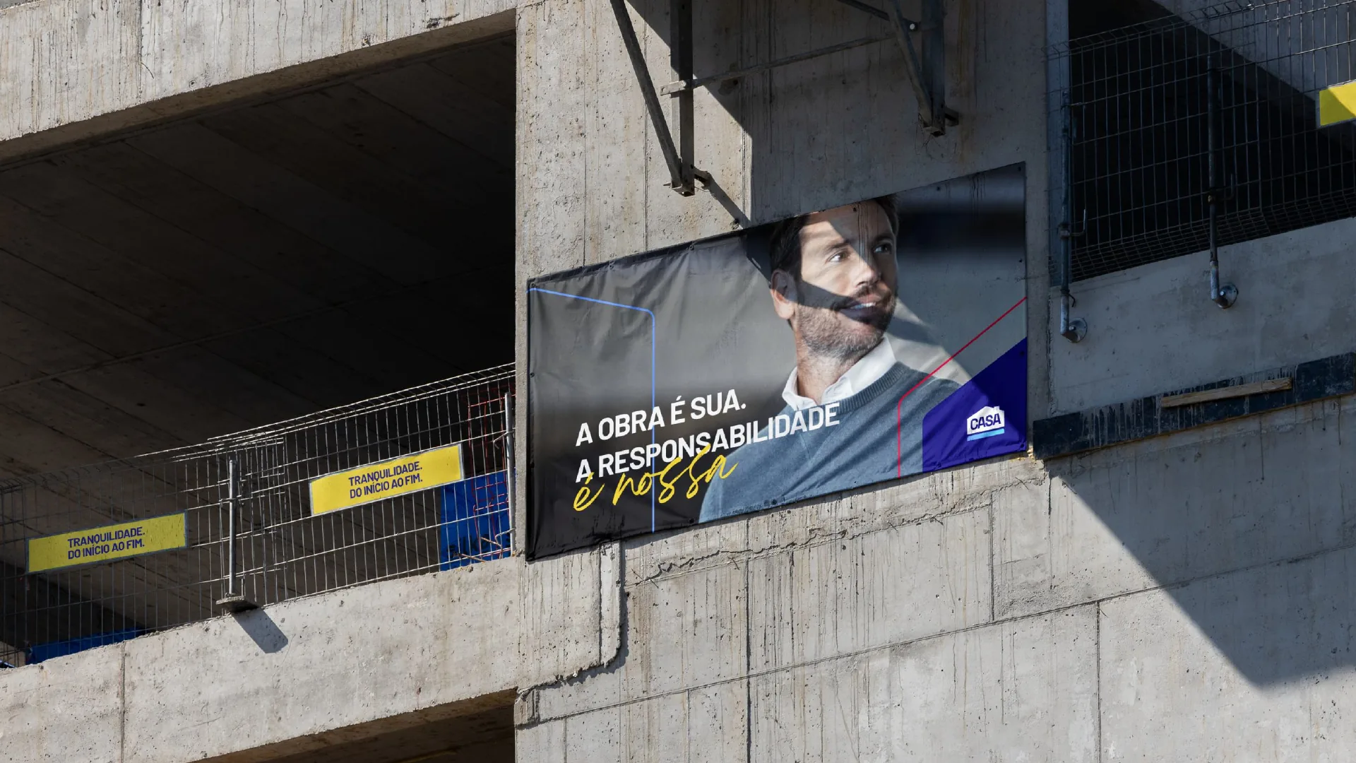 Lona da CASA numa obra, com a frase «A obra é sua. A responsabilidade é nossa.»